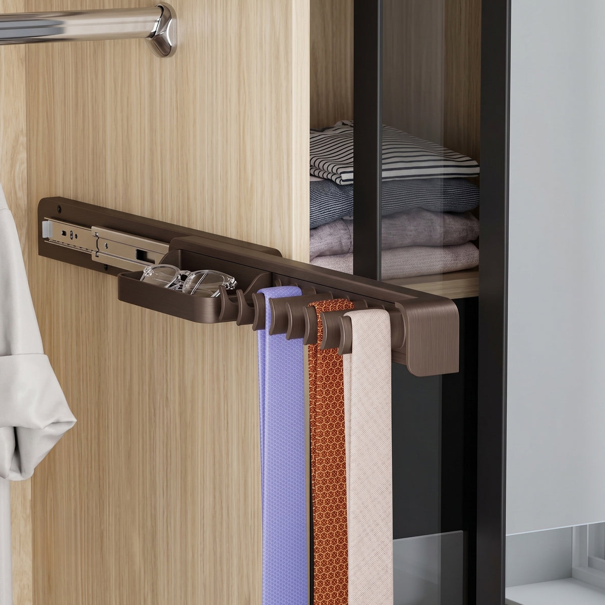 A brown, slide-out tie and belt organizer mounted to the interior side of a light wood wardrobe. The rack is extended on its metal track, displaying three hanging ties and featuring a small front storage tray holding a pair of eyeglasses.