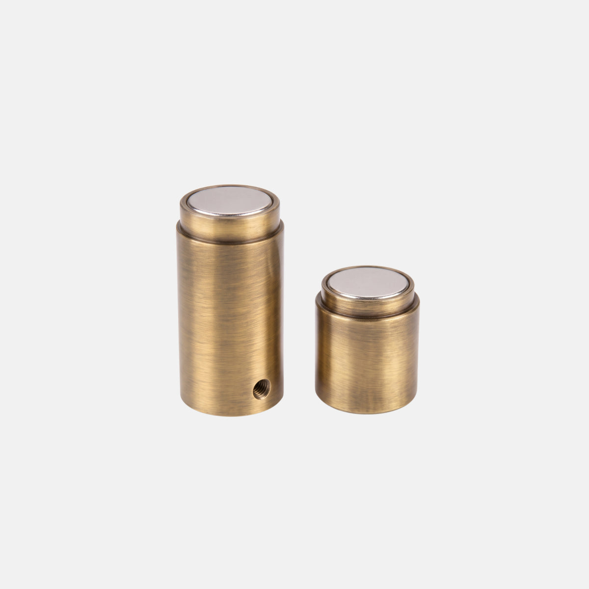 Two-piece cylindrical round solid brass magnetic door holder showing concealed set screw hole and flat magnet faces