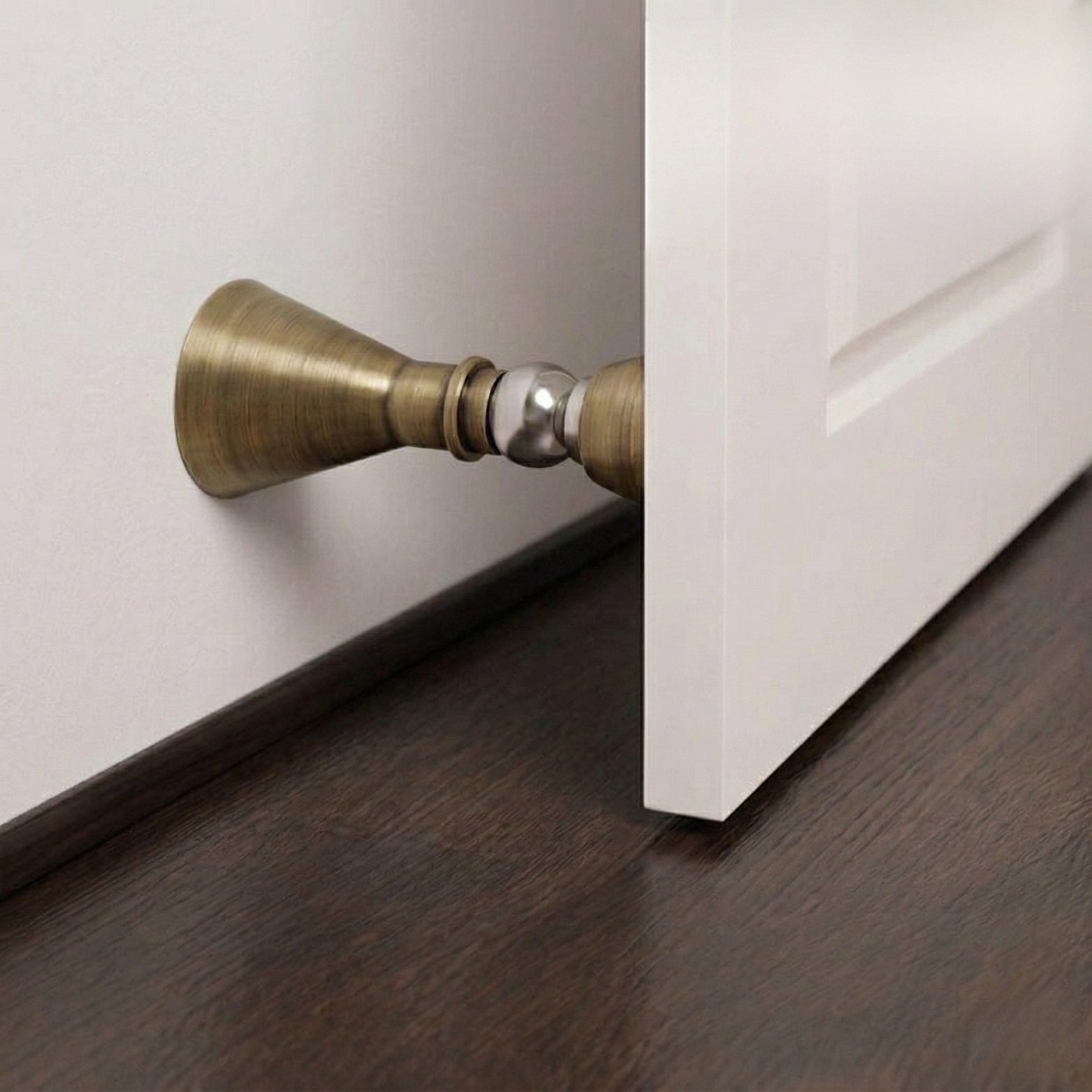 Magnetic Door Stopper Mounted on White Wall Holding Door