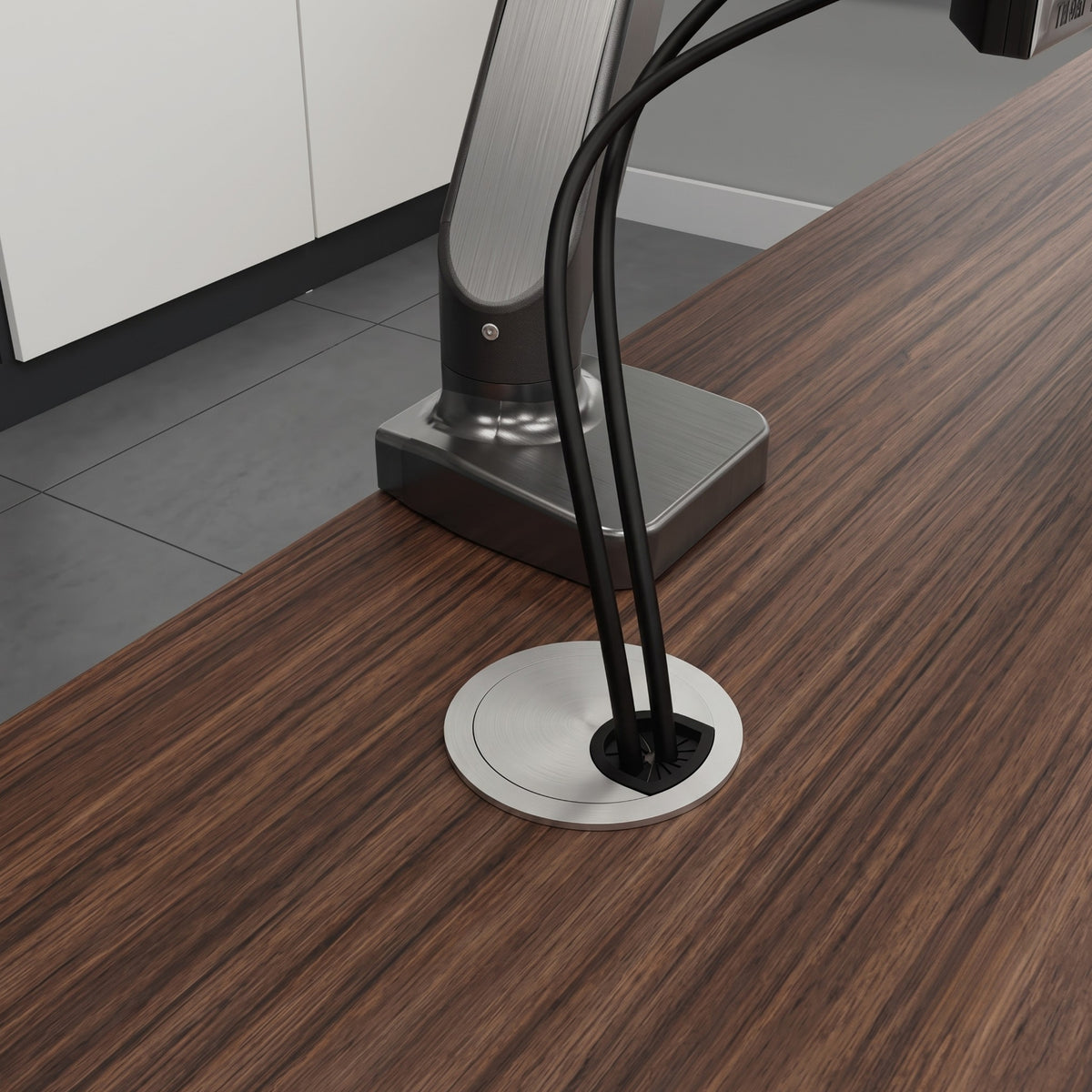 Ebco Zinc Cable Organiser installed on a wooden office desk, neatly routing monitor cables for a clean and professional workstation setup