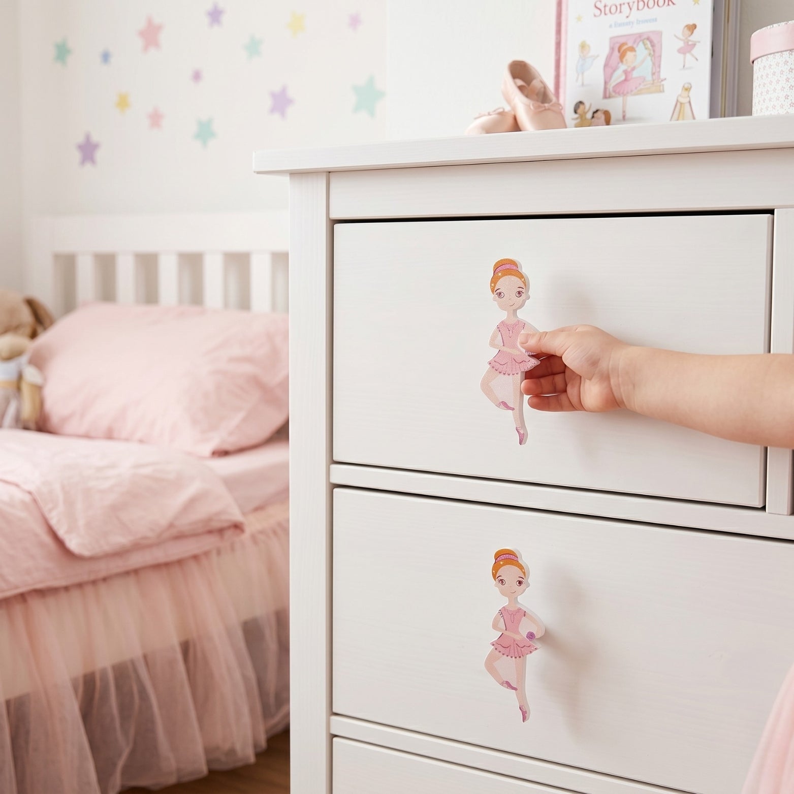 Close-up of a child’s hand pulling the premium pink ballerina acrylic handle from Hardware Depot's designer kids collection.