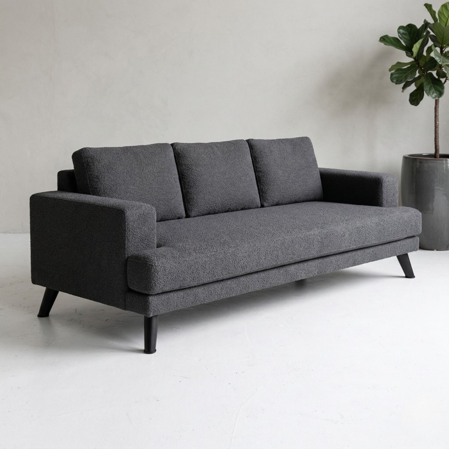 Modern charcoal grey boucle sofa featuring 4-inch matt black slanted stainless steel legs from Hardware Depot Bangalore