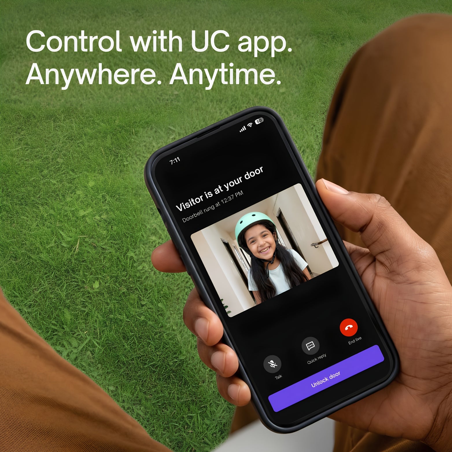 Close-up of a person holding a smartphone on a green lawn background, showing a visitor alert on the mobile app interface with a live video of a smiling young girl wearing a bicycle helmet. Text on image reads: "Control with UC app. Anywhere. Anytime