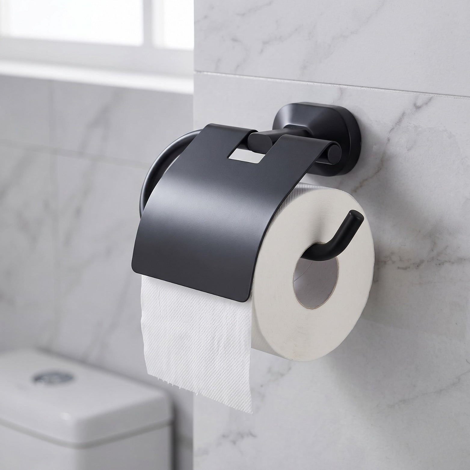 Sparrow SS304 stainless steel toilet paper holder in matt black finish mounted on a marble bathroom wall with a toilet roll